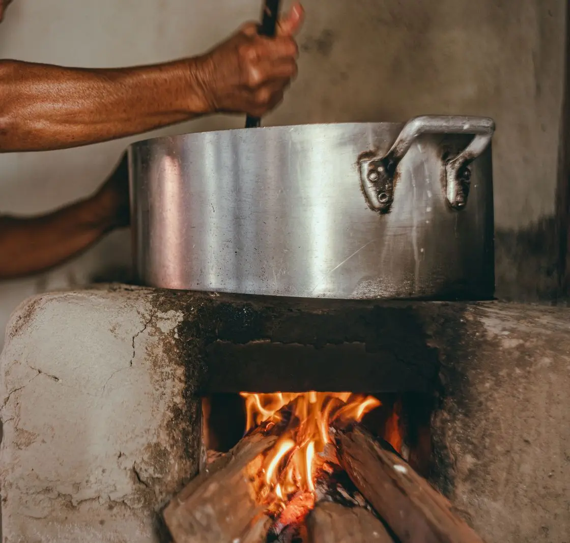 Ateşteki kazanın başında karıştırılan yemek